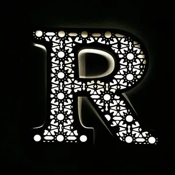 حرف R مخرّم بنقشة هندسية يضيء من الداخل