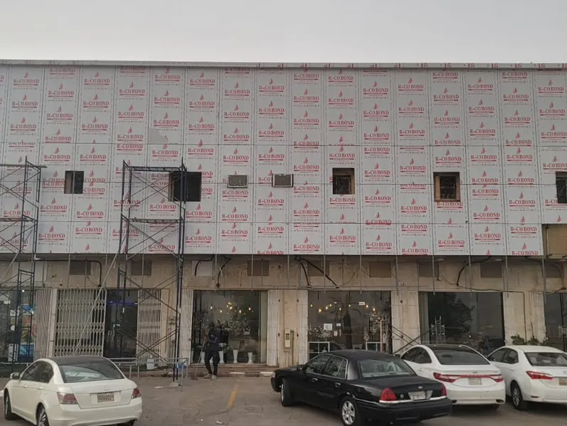 واجهة مجمّع تجاري من طابقين مكسوّة بألواح كلادينج ما زال عليها الغلاف الواقي