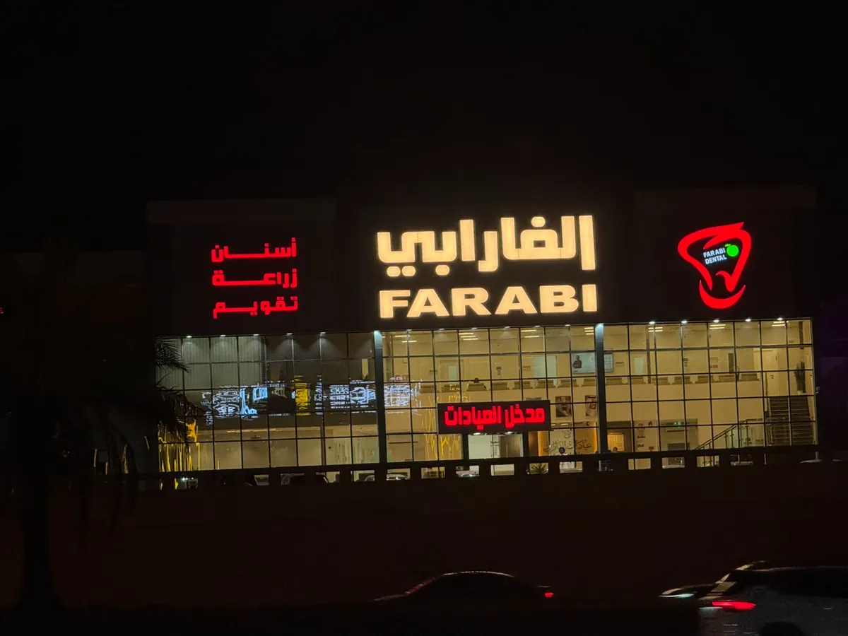 لوحة الفارابي بأحرف مضيئة ليلاً فوق واجهة عيادات أسنان