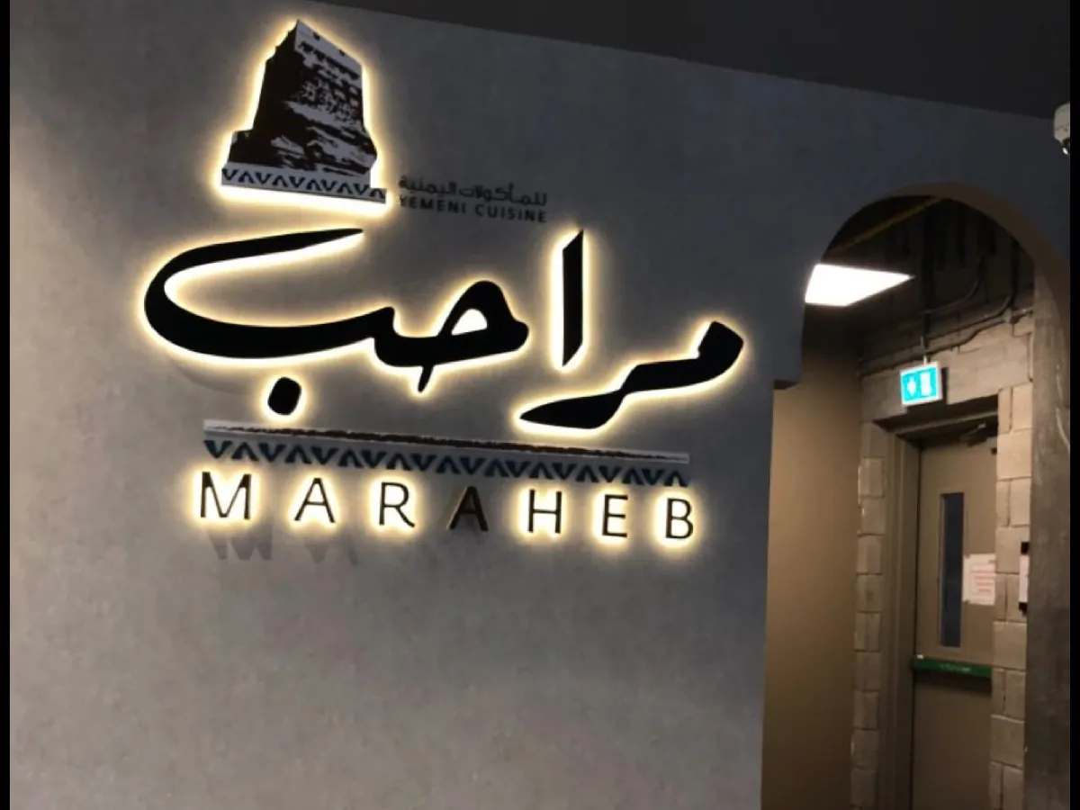 شعار وأحرف مطعم مراحب بإضاءة خلفية على جدار المدخل