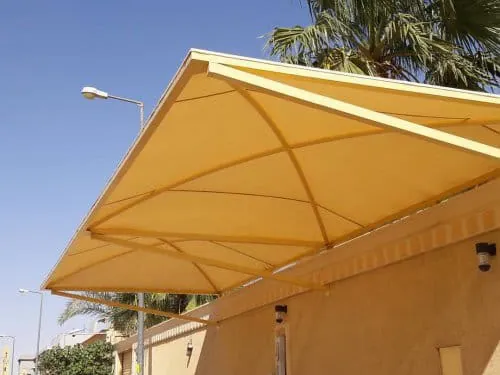 مظلة هرمية صفراء مثبتة على سور منزل