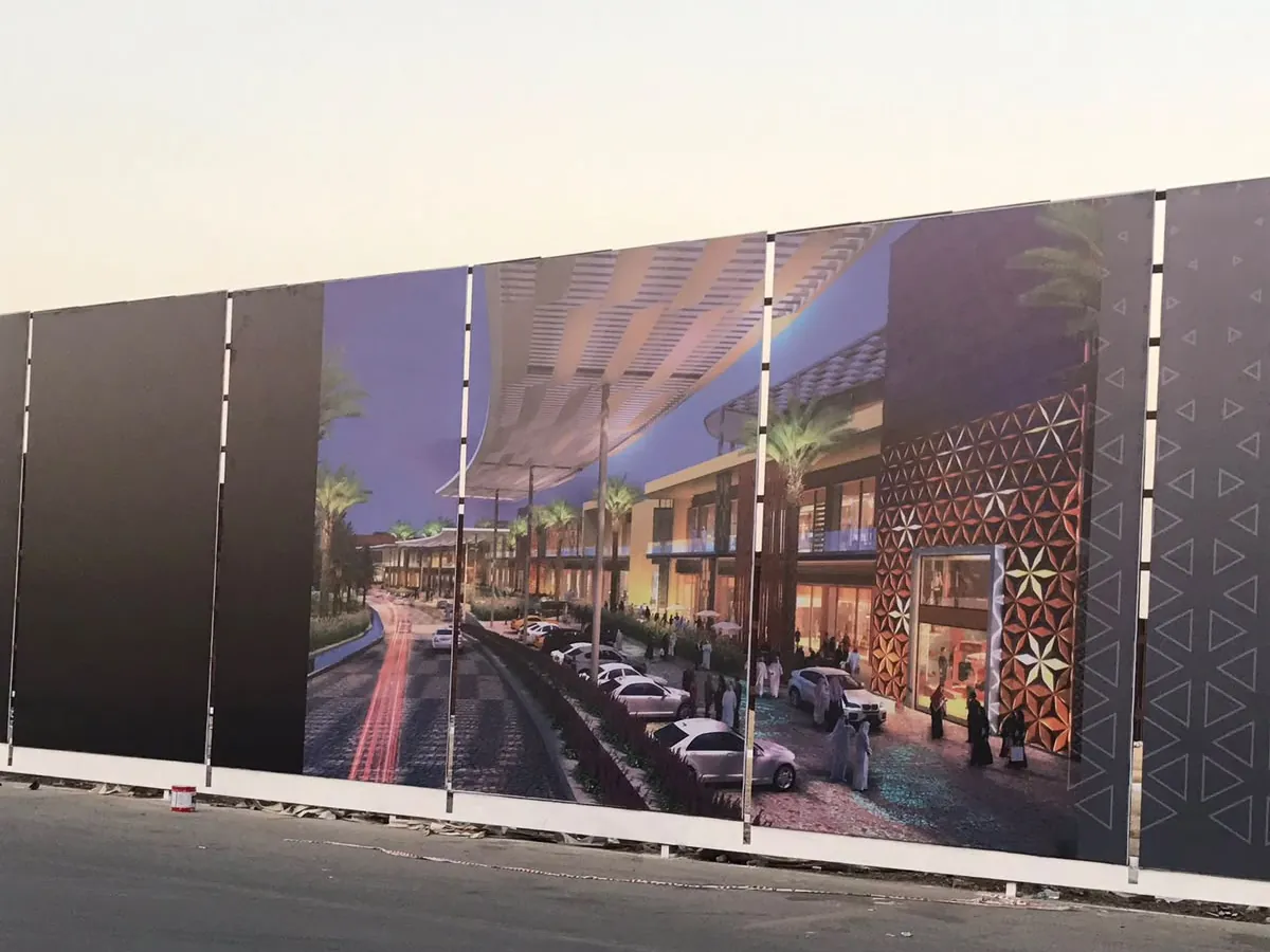 سور موقع إنشائي مطبوع عليه منظور المشروع التجاري