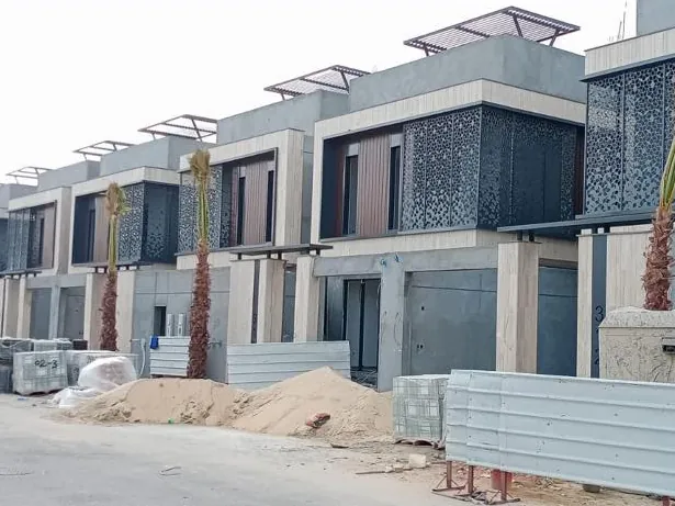 صف فلل بسواتر معدنية مخرّمة على البلكونات وواجهات بلون الخشب
